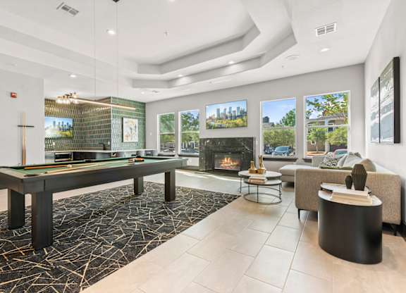 A modern living room with a pool table and a fireplace.