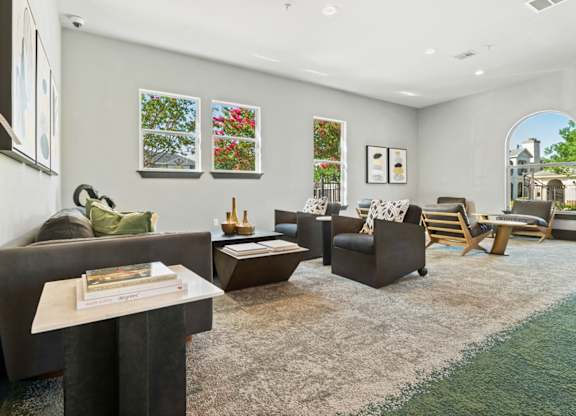 A living room with a grey couch, a brown armchair, a coffee table, and a rug.
