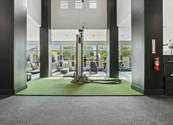 A gym with a green mat and a red fire extinguisher.