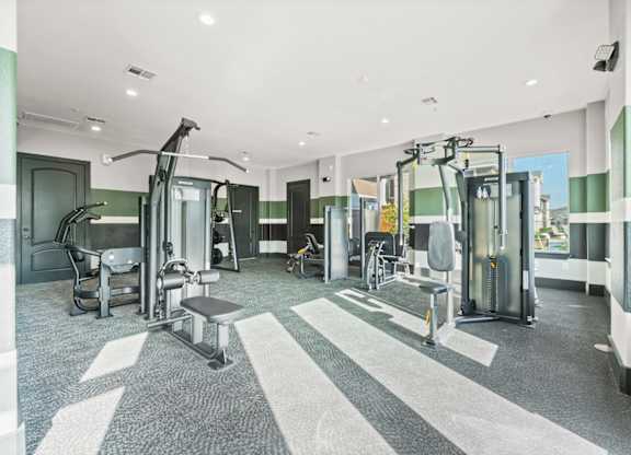 A gym with a variety of equipment including treadmills, weights, and exercise machines.