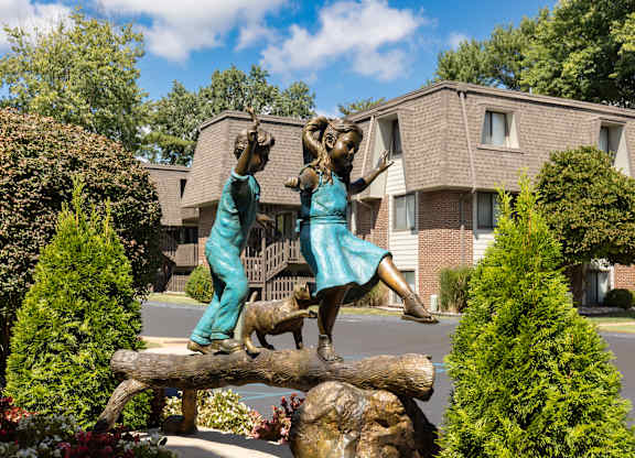 A statue of two people on a log in front of a building.