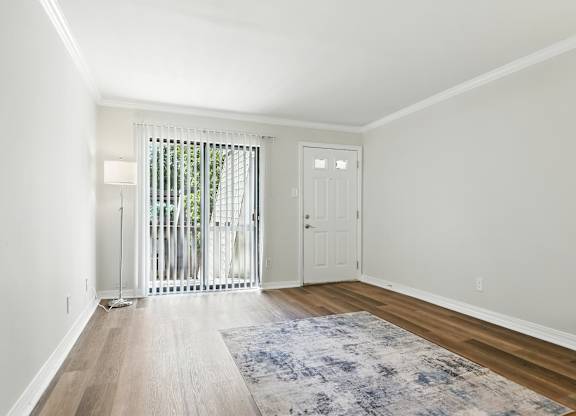 A room with a white door and a window with a white curtain.