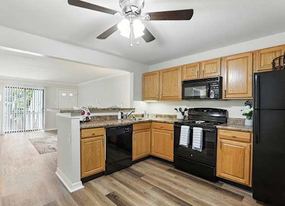 A kitchen with wooden cabinets and black appliances.