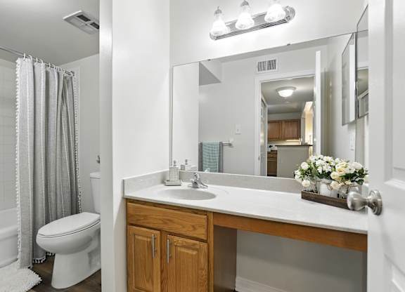A white bathroom with a toilet, sink, and shower.