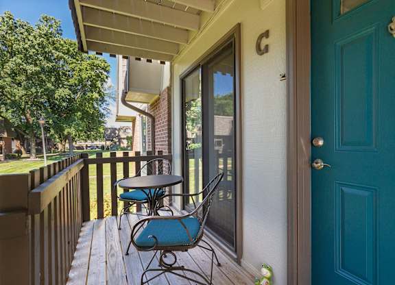 A blue chair is on a wooden deck.