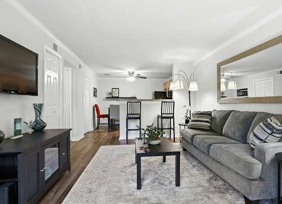 A living room with a grey couch and a wooden coffee table.