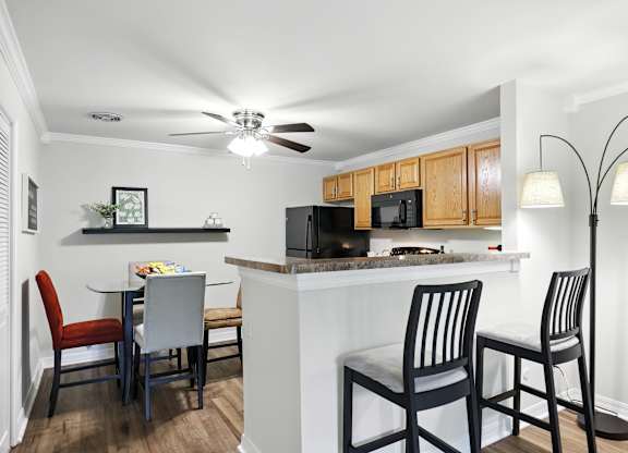 A kitchen with a table and chairs.