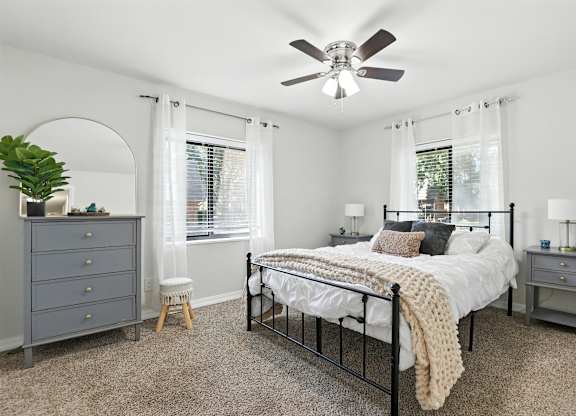 A bedroom with a bed, dresser, and window.