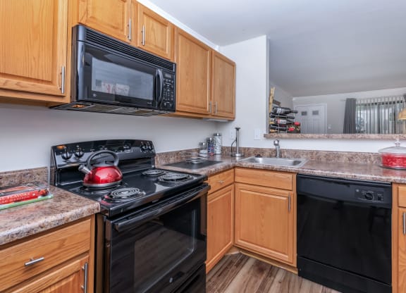 a kitchen with wood cabinets and black appliances