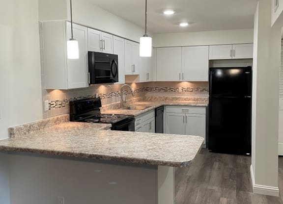a kitchen with white cabinets and a granite counter top