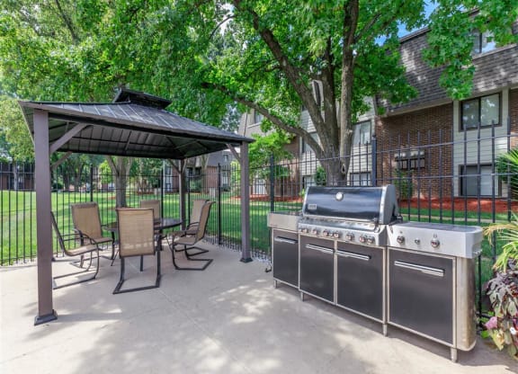 our outdoor patio with a grill and a gazebo with chairs and tables