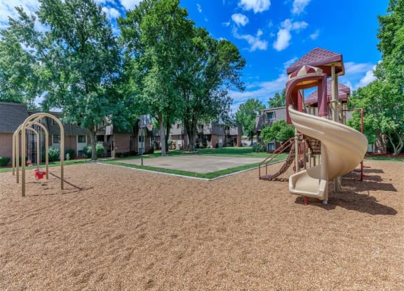a playground with a slide at an apartment complex