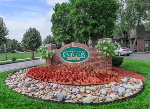 the sign estates in front of a stone retaining wall with red