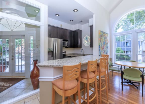 a kitchen with a bar and a table with chairs
