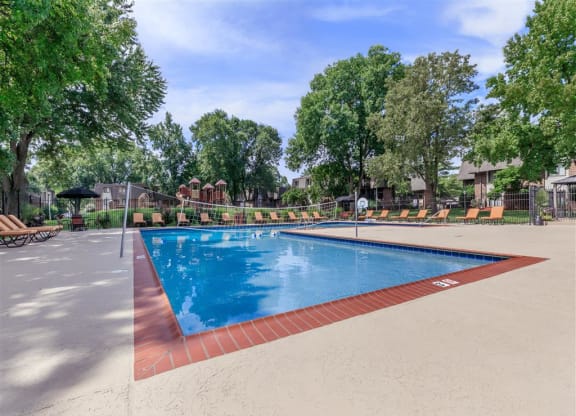 a swimming pool with trees and a fence around it