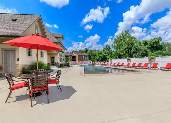 a swimming pool with a table and chairs next to a house