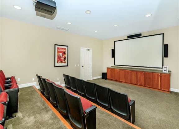 a theater room with a projector screen and chairs