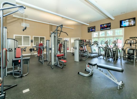 a gym with weights and cardio equipment and tv