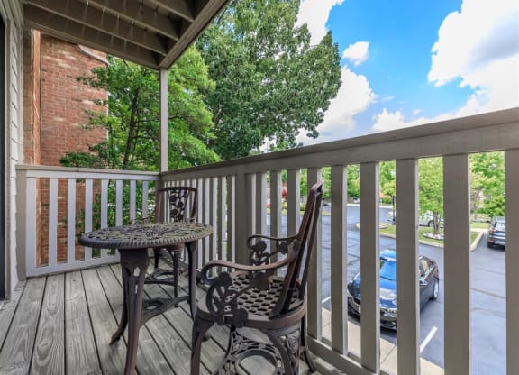 a patio with two chairs and a table on a balcony