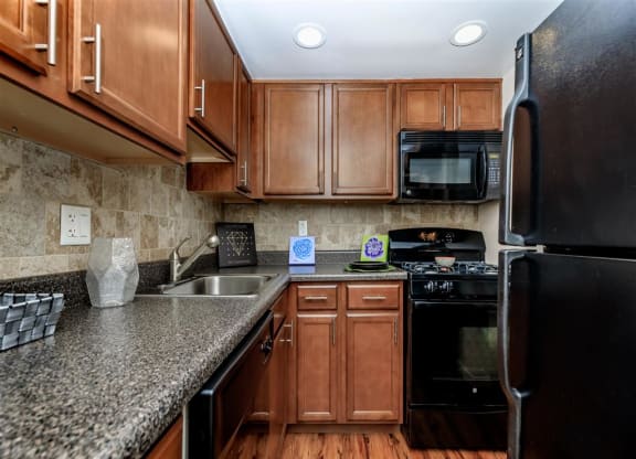 a kitchen with granite counter tops and black appliances