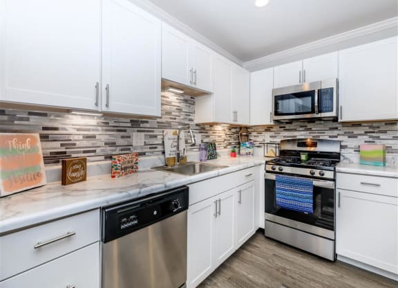 a kitchen with stainless steel appliances and white cabinets