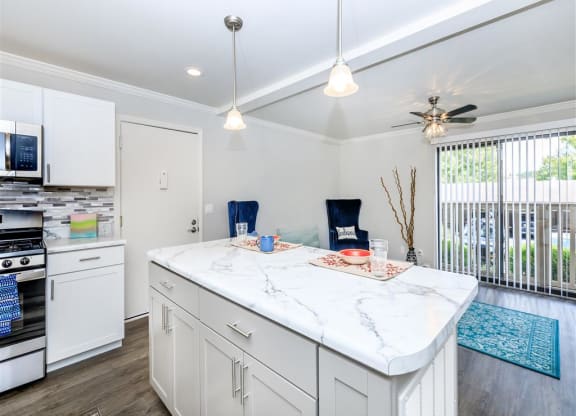 a white kitchen with a large island and a window