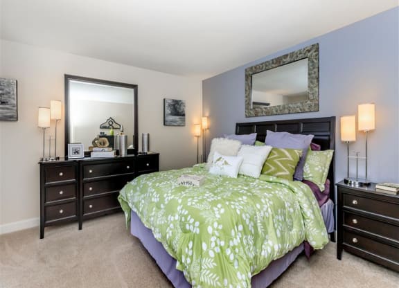 a bedroom with a bed and two dressers