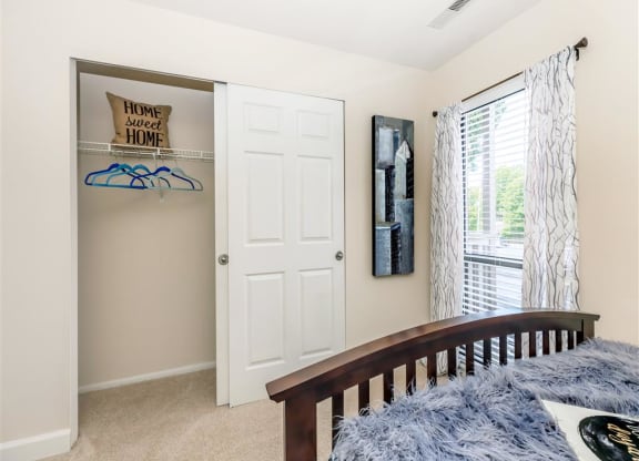 a bedroom with a bed and a closet and a window