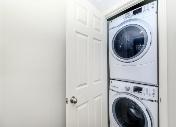 a white door to a white washer and dryer in a white laundry room