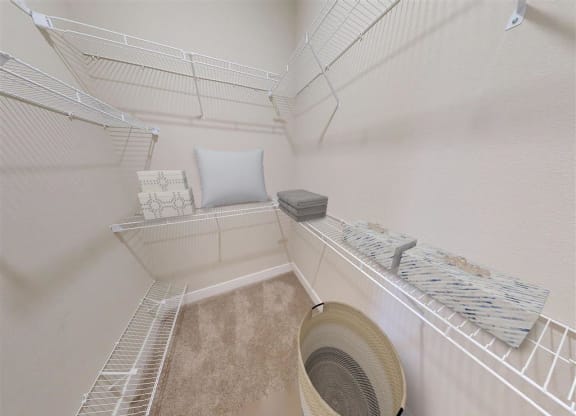 a walk in closet with a bed and a fan