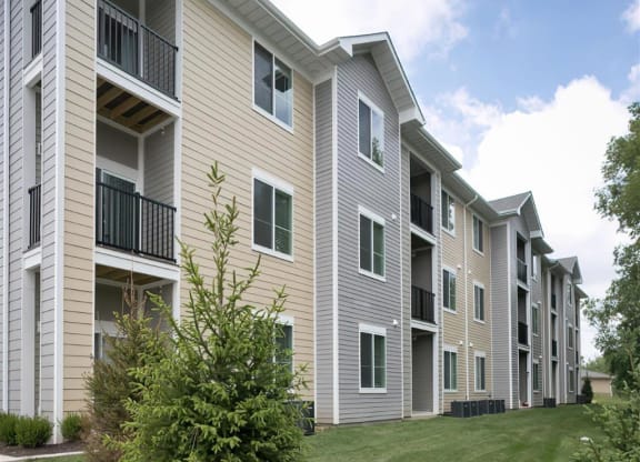 an exterior view of an apartment building with grass