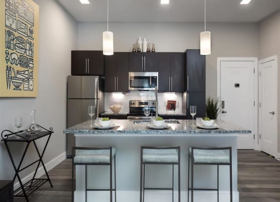 a kitchen with a counter top with three stools