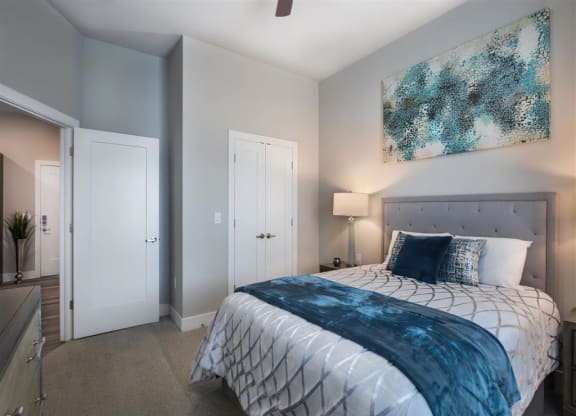 a bedroom with a bed and a painting on the wall