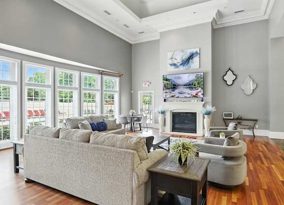 A living room with a grey couch and a fireplace.