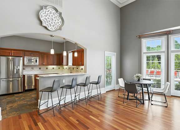 A kitchen with a dining table and chairs.