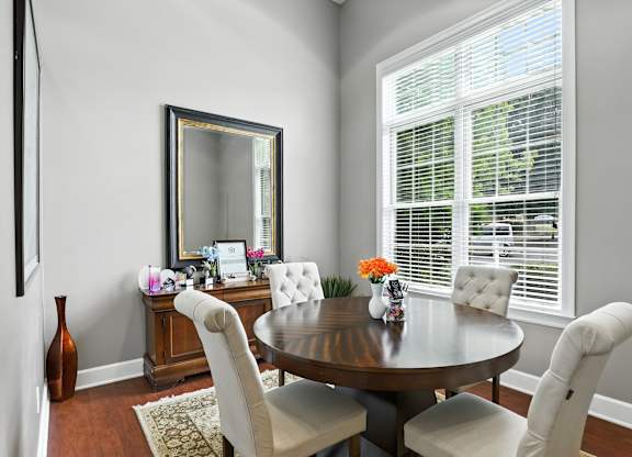 A dining room with a round table and chairs.