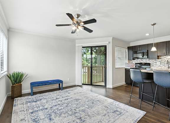 A blue rug is on the floor of a room with a ceiling fan.
