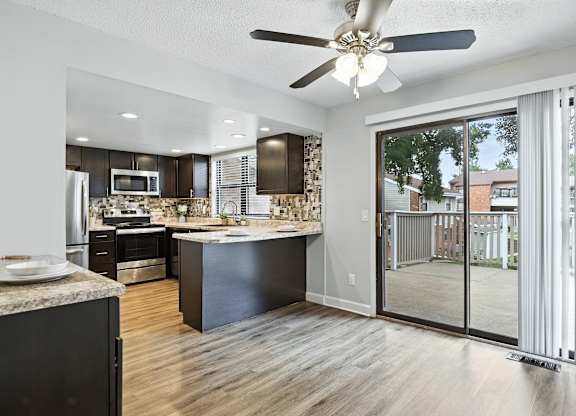 A modern kitchen with a large island and a view of the backyard.
