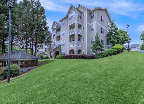 A large apartment building with a green lawn in front.