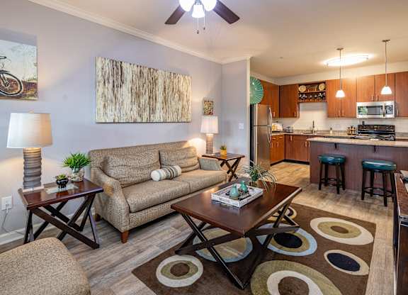 A living room with a couch, a coffee table, and a painting on the wall.