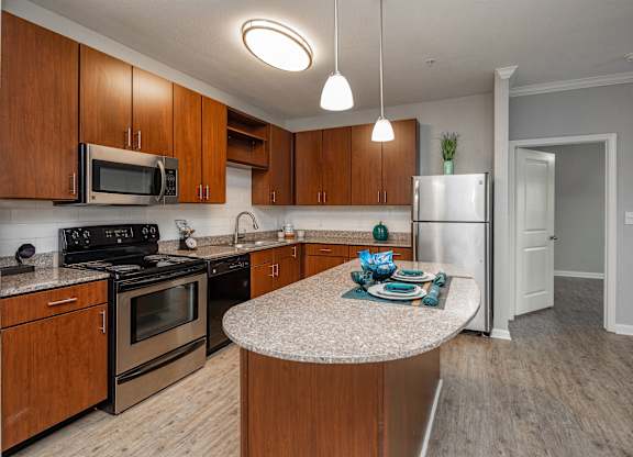 A kitchen with wooden cabinets and a granite countertop.