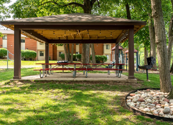 a gazebo with a picnic table and a fire pit
