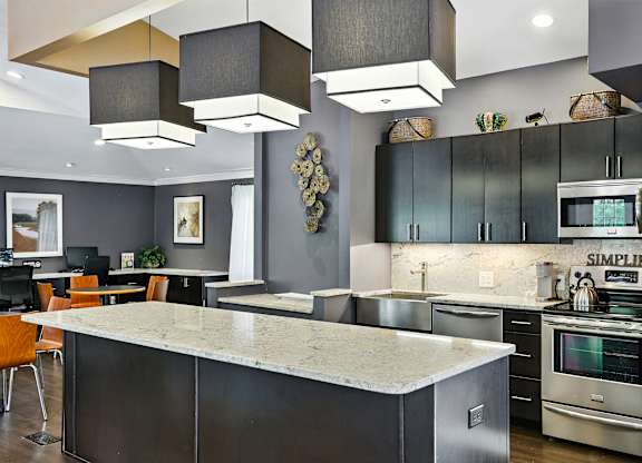 A modern kitchen with a marble island and stainless steel appliances.