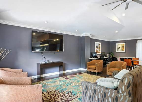 A living room with a grey wall and a television.