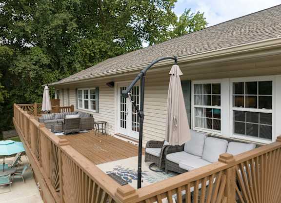 A patio with a couch, chairs, and a table.