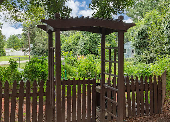 A wooden gate with a pergola above it.