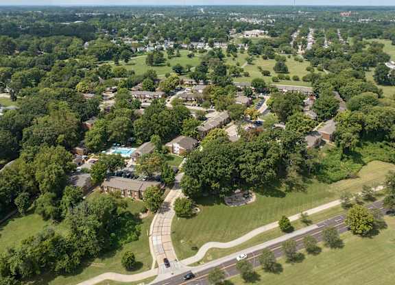 A bird's eye view of a residential area with houses, roads, and greenery.