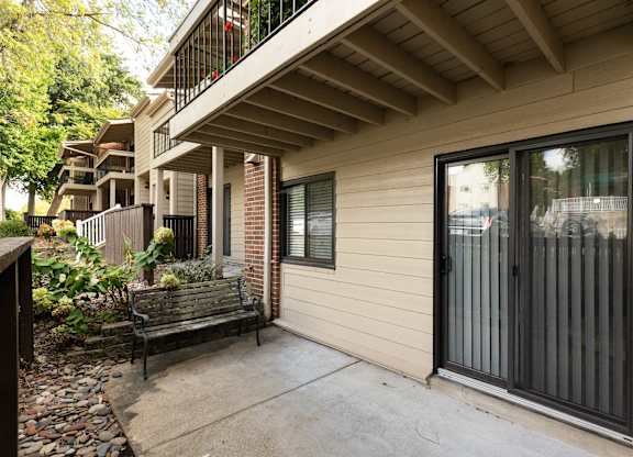 A balcony with a bench and a window with a black frame.