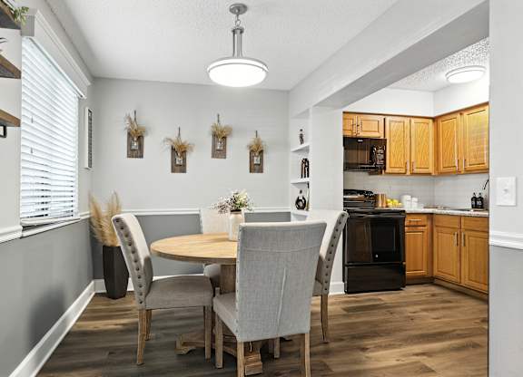 A kitchen with a table and chairs in the middle of the room.