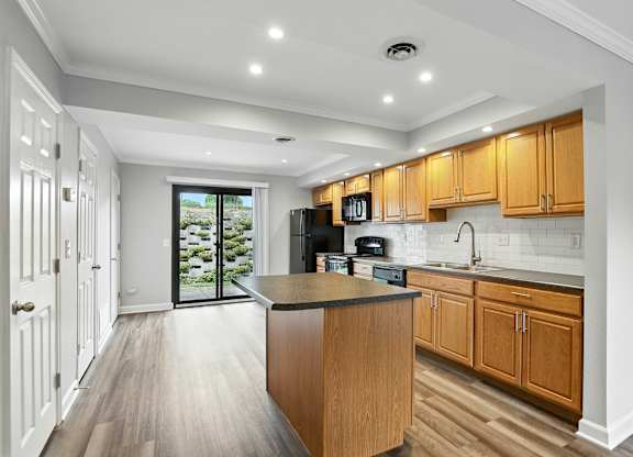 A kitchen with wooden cabinets and a black countertop.
